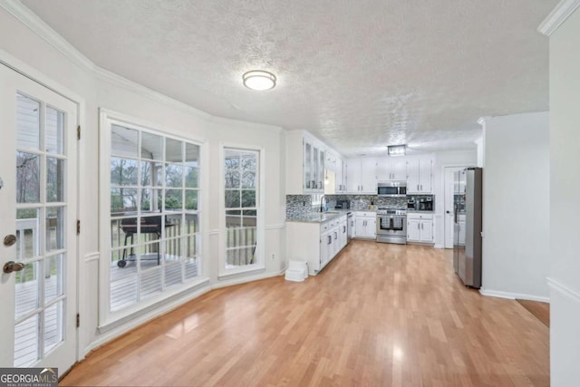 kitchen featuring a sink, decorative backsplash, light wood finished floors, and stainless steel appliances