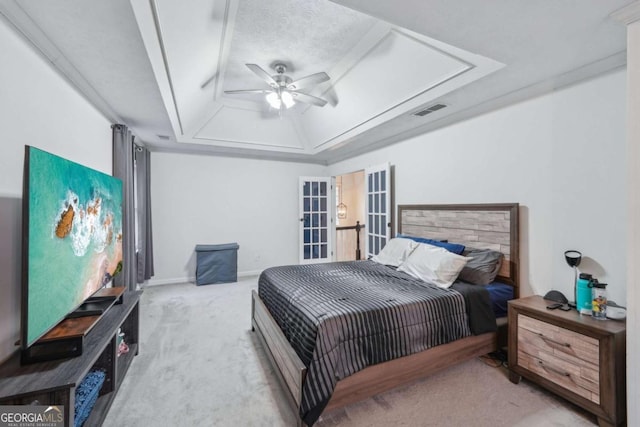 bedroom with visible vents, carpet, a tray ceiling, french doors, and a ceiling fan