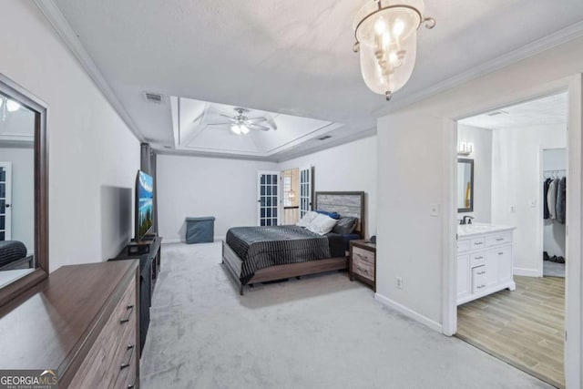 bedroom featuring visible vents, baseboards, ornamental molding, a raised ceiling, and a sink