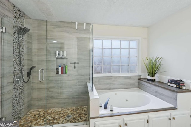 bathroom featuring a shower stall, a textured ceiling, and a jetted tub