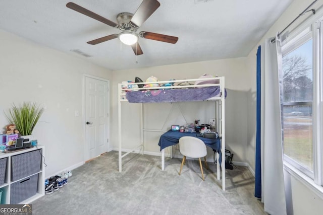 carpeted bedroom with visible vents, baseboards, and a ceiling fan