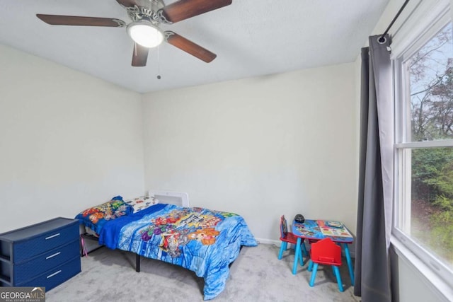 bedroom featuring multiple windows, carpet, and a ceiling fan