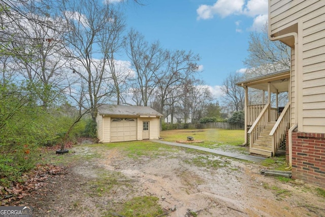 view of yard featuring an outbuilding, a garage, and dirt driveway