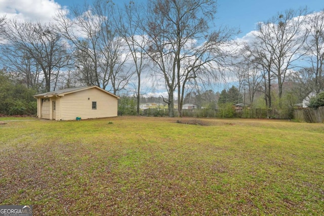 view of yard featuring an outdoor structure and fence