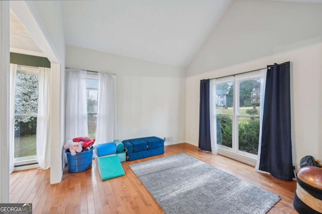 sitting room featuring hardwood / wood-style flooring and high vaulted ceiling