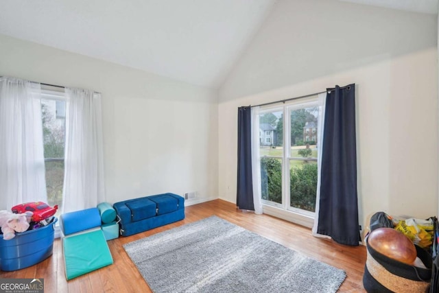 sitting room featuring visible vents, high vaulted ceiling, and wood finished floors