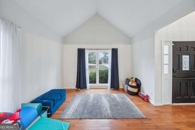 foyer with vaulted ceiling, wood finished floors, and baseboards