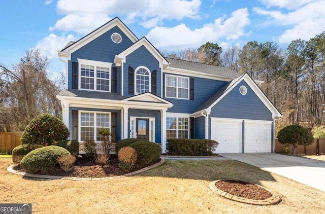 traditional-style home with concrete driveway, an attached garage, and fence