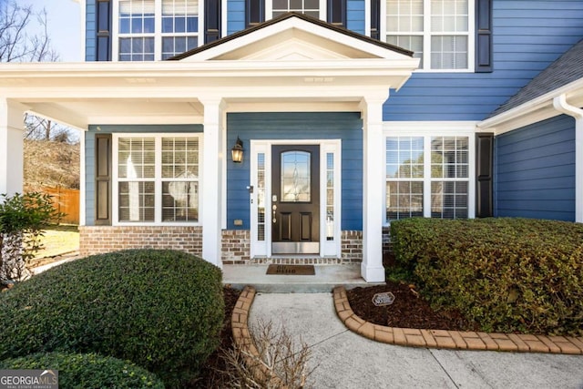 property entrance featuring brick siding and a porch