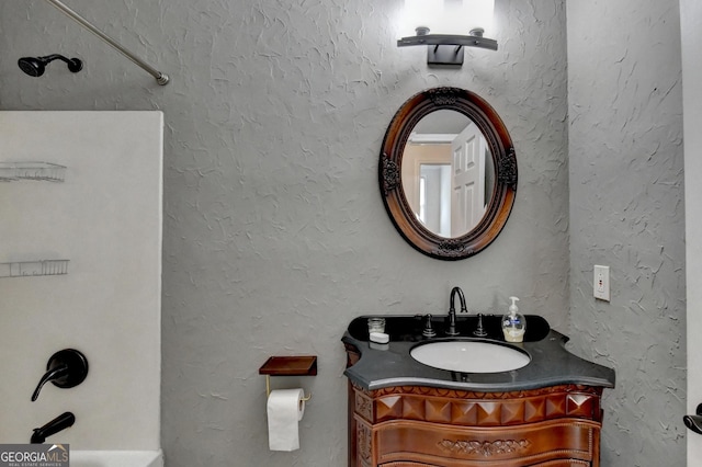 full bath featuring shower / washtub combination, vanity, and a textured wall
