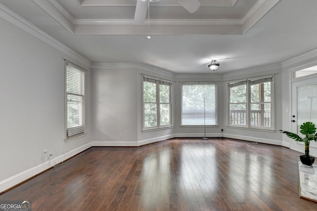 spare room with dark wood finished floors, a tray ceiling, crown molding, and baseboards