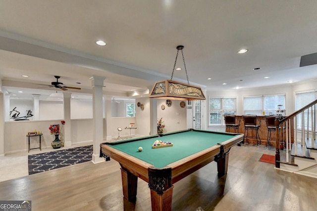playroom featuring recessed lighting, a bar, wood finished floors, and ornate columns