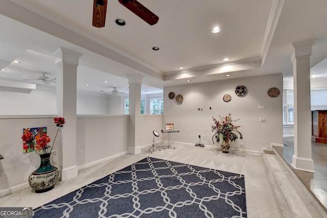 interior space featuring a tray ceiling, decorative columns, and ceiling fan