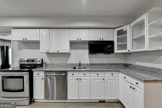 kitchen with a sink, white cabinetry, stainless steel appliances, light wood finished floors, and glass insert cabinets