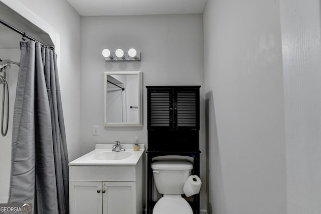bathroom featuring toilet, vanity, and a shower with shower curtain
