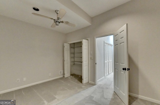 unfurnished bedroom with light colored carpet, a ceiling fan, and baseboards