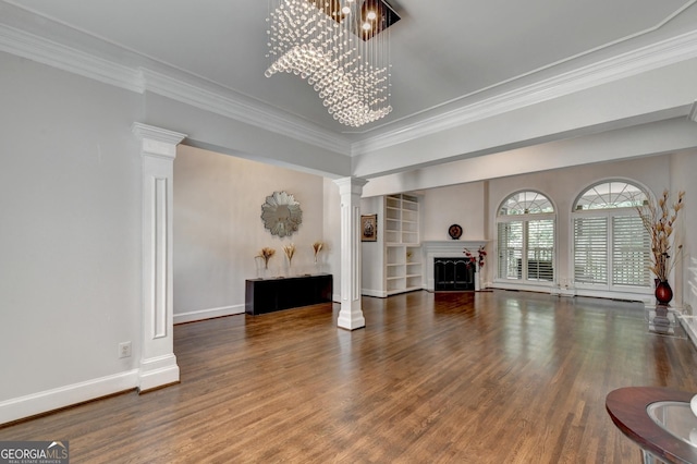 living room featuring a chandelier, a fireplace, wood finished floors, and decorative columns