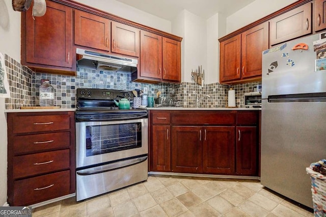 kitchen with under cabinet range hood, a sink, backsplash, stainless steel appliances, and light countertops