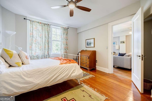 bedroom featuring wood finished floors, baseboards, and ceiling fan