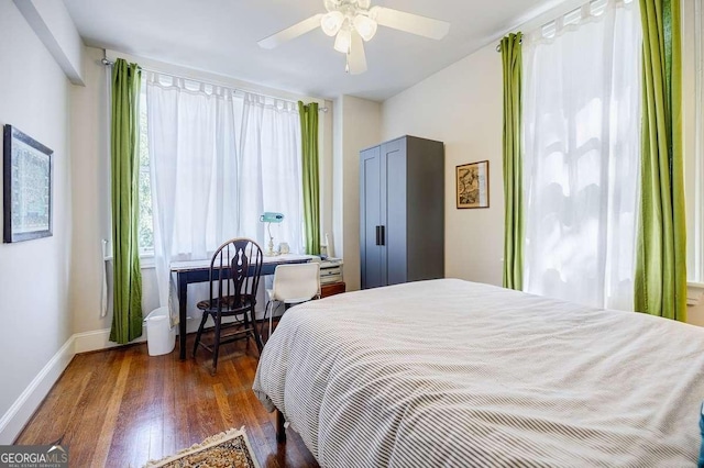 bedroom with dark wood-style floors, baseboards, and ceiling fan