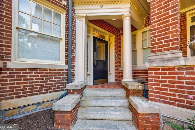 entrance to property with brick siding and a porch