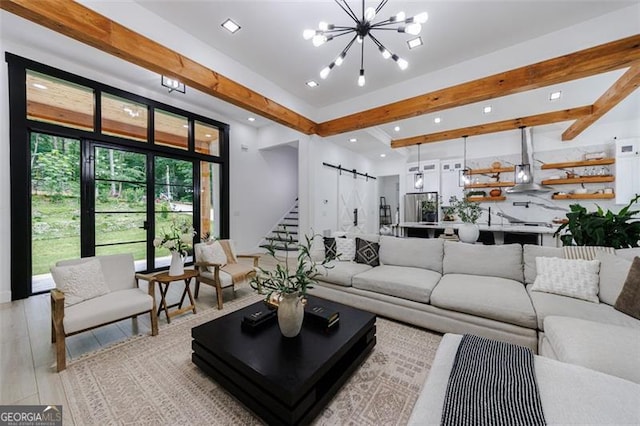 living area with beam ceiling, recessed lighting, a barn door, stairway, and a chandelier