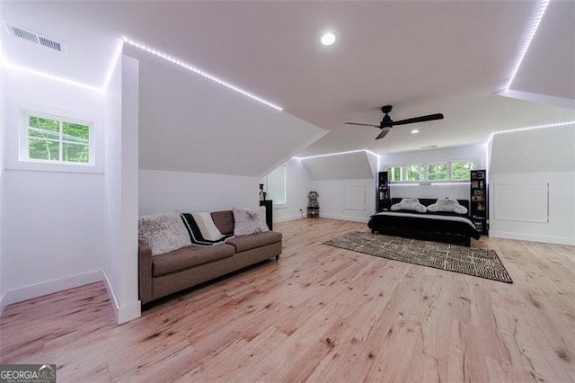 bedroom featuring visible vents, lofted ceiling, multiple windows, and wood finished floors