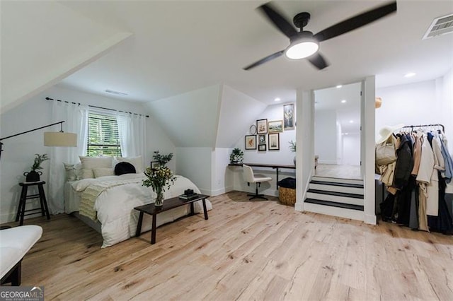 bedroom with visible vents, light wood-style flooring, ceiling fan, and vaulted ceiling