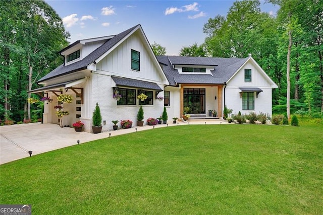 modern inspired farmhouse with a front lawn, driveway, board and batten siding, a garage, and brick siding