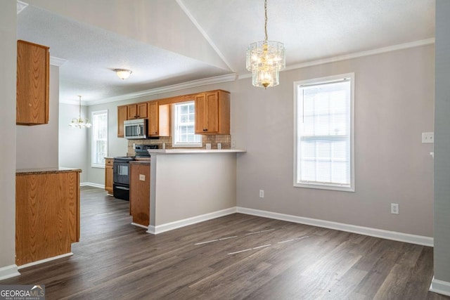 kitchen featuring black electric range, stainless steel microwave, brown cabinets, and a notable chandelier