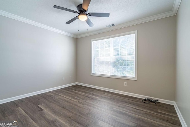 spare room with visible vents, baseboards, dark wood-style floors, and ornamental molding