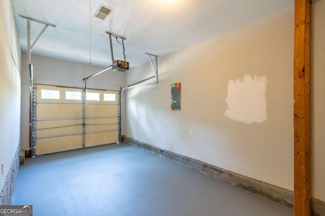 garage featuring electric panel, visible vents, and a garage door opener