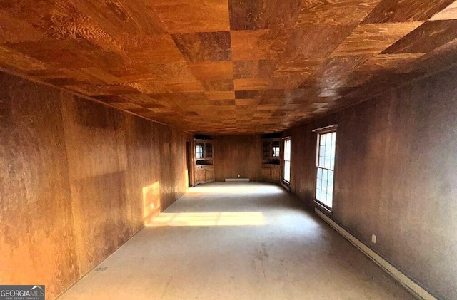 empty room featuring wooden ceiling and wood walls