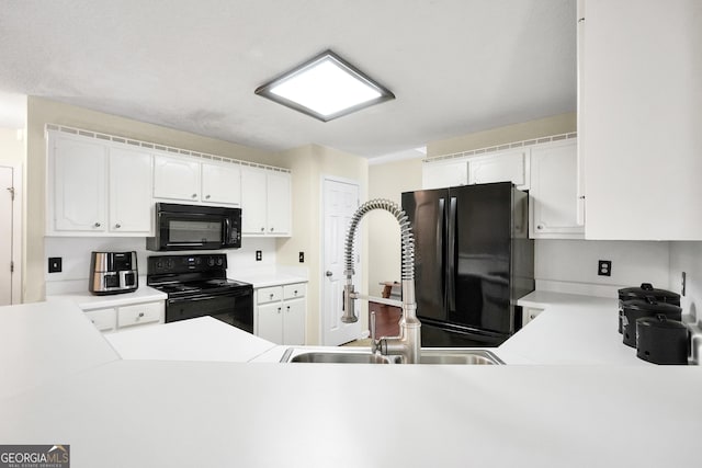 kitchen featuring white cabinets, black appliances, light countertops, and a sink