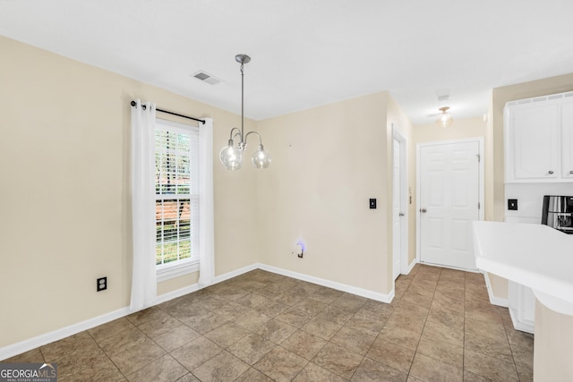 unfurnished dining area featuring a notable chandelier, baseboards, and visible vents