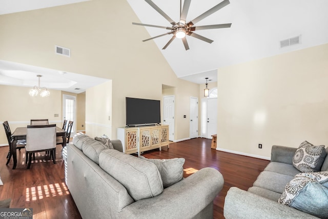 living area featuring dark wood-style floors, visible vents, ceiling fan with notable chandelier, and baseboards