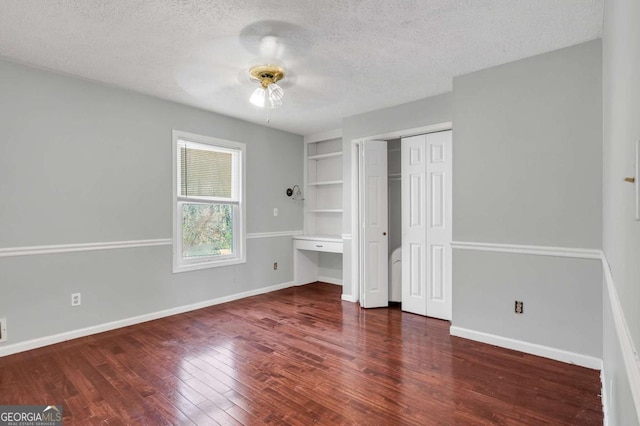 unfurnished bedroom with baseboards, ceiling fan, hardwood / wood-style flooring, a closet, and a textured ceiling