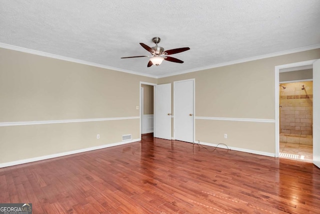 unfurnished bedroom with visible vents, crown molding, baseboards, wood finished floors, and a textured ceiling