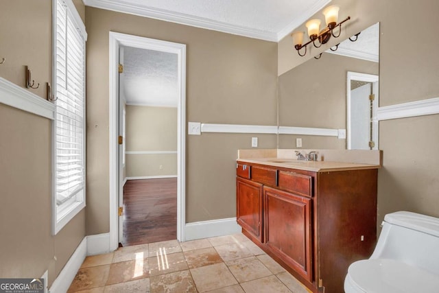 bathroom featuring toilet, a textured ceiling, crown molding, baseboards, and vanity