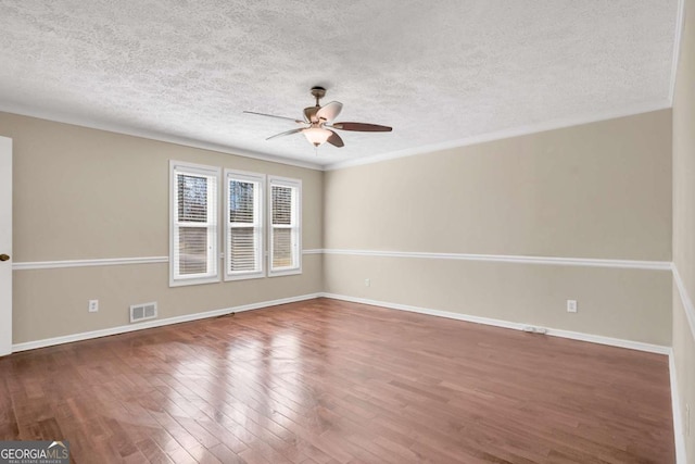 spare room with visible vents, baseboards, a ceiling fan, and wood finished floors