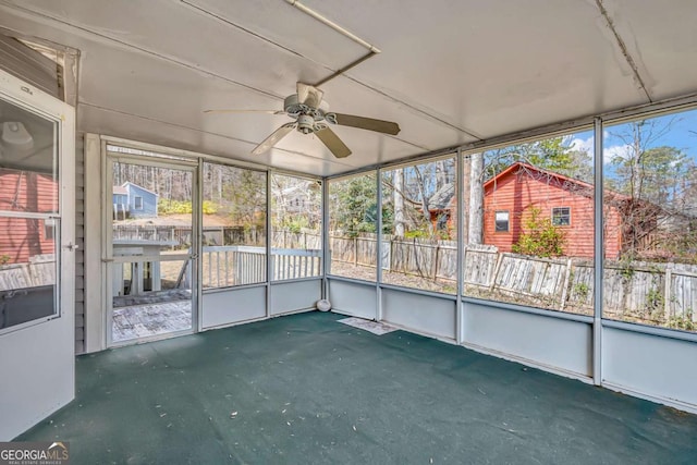 unfurnished sunroom featuring a ceiling fan