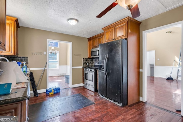 kitchen featuring dark wood-style floors, decorative backsplash, stainless steel appliances, and brown cabinetry