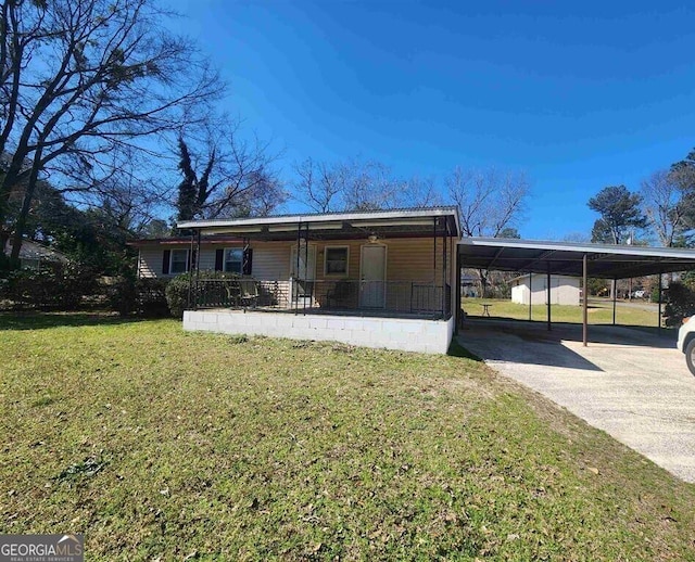 view of front of property featuring a front lawn, concrete driveway, a carport, and a porch