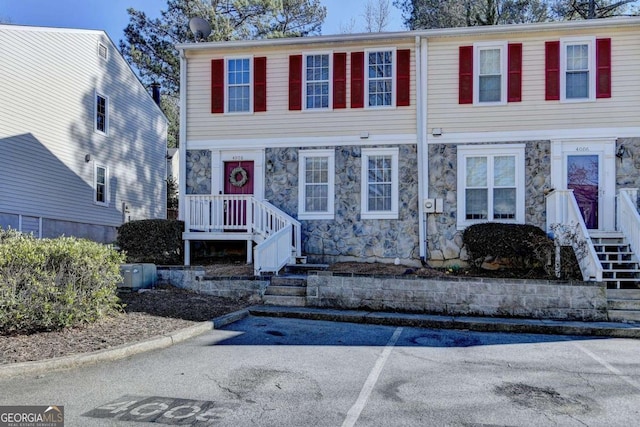 view of front of home featuring uncovered parking and stone siding