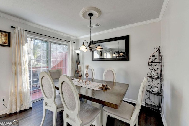 dining room featuring baseboards, visible vents, dark wood finished floors, crown molding, and a notable chandelier