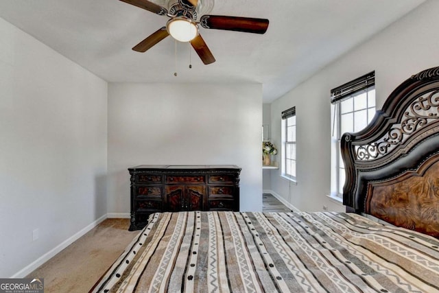 bedroom with a ceiling fan, baseboards, and carpet floors