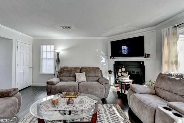 living room featuring visible vents, dark wood-type flooring, a fireplace, crown molding, and baseboards