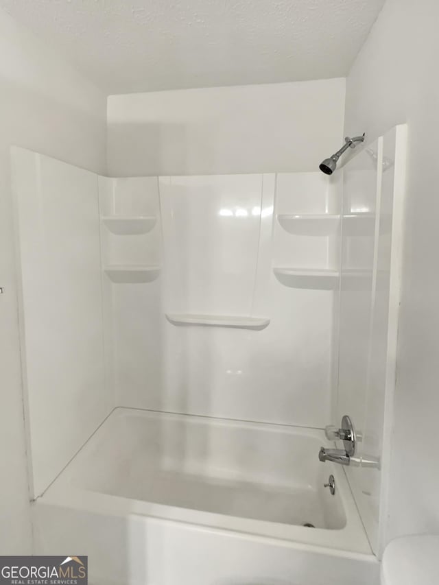 bathroom featuring a textured ceiling and toilet