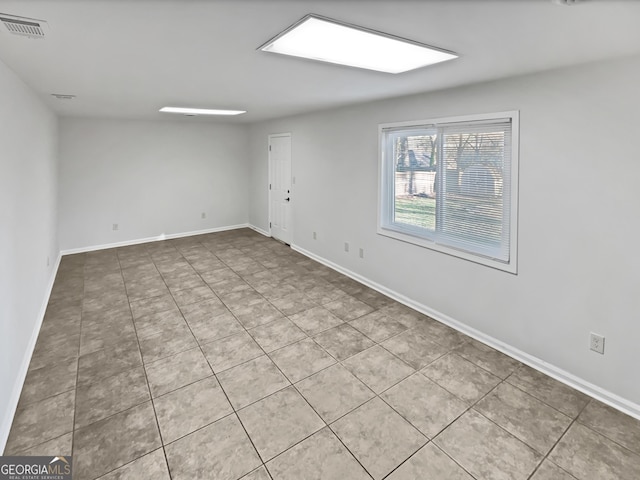 unfurnished room featuring baseboards and visible vents