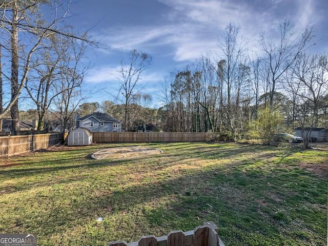 view of yard featuring an outbuilding, a storage shed, and fence private yard